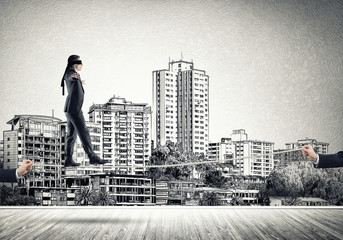 Business concept of risk support and assistance with man balancing on rope