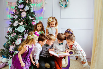 Group of the lovely children are reading a book