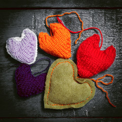 Valentine's Day. Colorful knitted hearts. Red heart on the dark boards. Valentines day. Heart...
