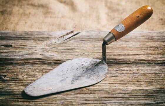 Old trowel on wooden background
