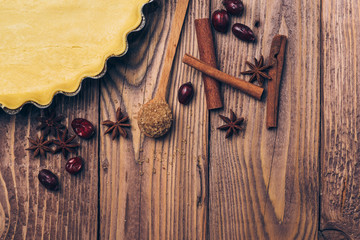 Ingredients for apple tart, apples and cinnamon on rustic wooden background.