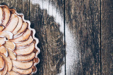 Apple pie tart on rustic wooden background. Ingredients - apples and cinnamon .Top view.