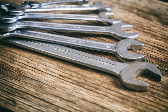 Set of wrenches on wooden background