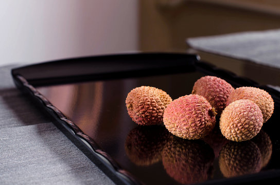 Fresh lychee on the dark glossy dish.