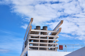 Smokestack or chimney at the top of a nautical vessel, with very little smoke coming out, against a...