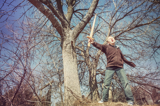 Boy playing with a sword outdoors