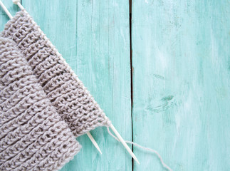 knitted scarf on turquoise wooden background