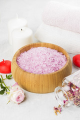 Obraz na płótnie Canvas Bath salt with aroma of a rose in a wooden bowl, petals and a fr