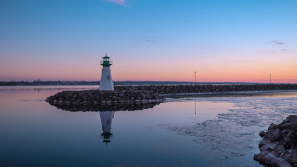 Fototapeta premium The Lighthouse Reflected in the River After Sunset