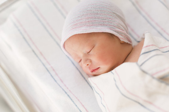 Newborn infant baby boy lying in a hospital bed