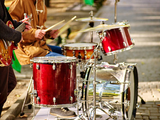 Fototapeta na wymiar Festival music band. Hands playing on percussion instruments in city park . Drums with sticks closeup. Body part of male musicians.