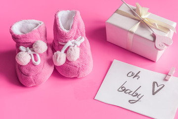 baby's bootees and gift box on wooden background