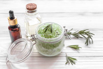 organic cosmetics with extracts of herbs rosemary on wooden background