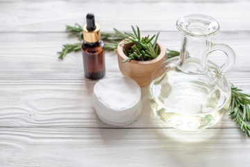 organic cosmetics with extracts of herbs rosemary on wooden background