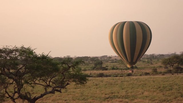 CLOSE UP: Safari hot air balloon flying close above the ground and ascending