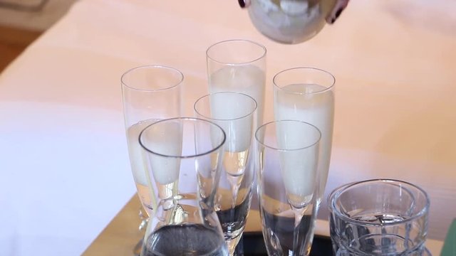 Sparkling wine filling in glasses at a wedding