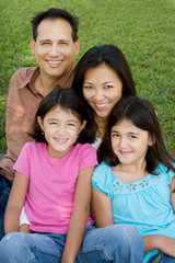 Fototapeta premium Loving Asain parents and their daughters smiling.