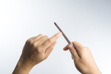Hand with nail file for polishing fingernails