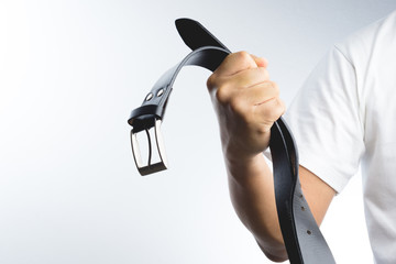 Hand holding leather belt for punishment, family violence  conce