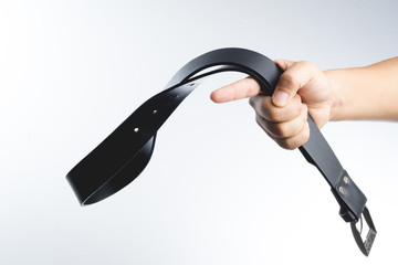 Hand holding leather belt for punishment, family violence  conce