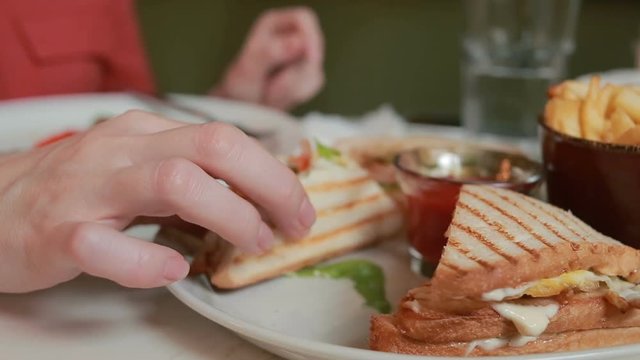 female hands holding otkusanny sandwich on a plate. Restaurant