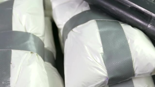 Seized drugs, money, gun, and burner phones on table