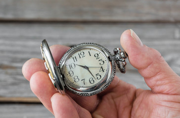 close up image of a caucasian hand holding a stop watch.