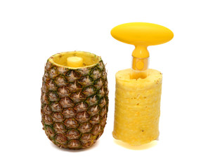A pineapple has been cored and sliced using a corer and slicer utensil