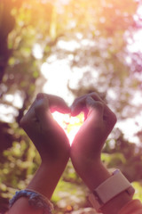 hand in shape of heart for love with blurred background