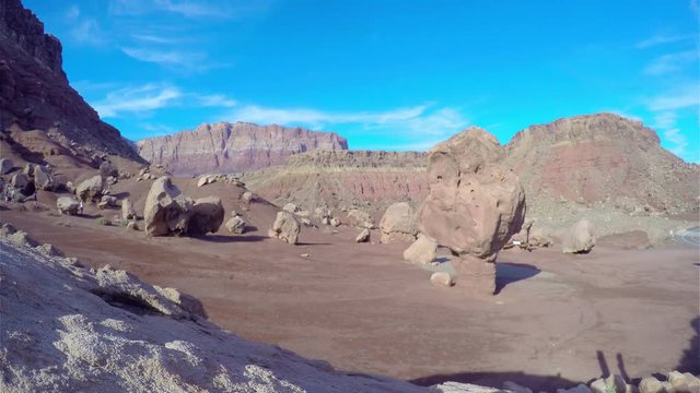 Timelapse of people walking around large stones, at a red desertf , like the planet mars, near marble canyon, in Arizona, United states of America