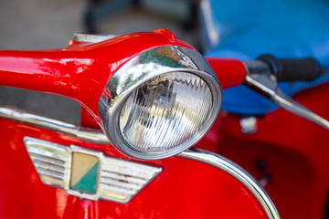 headlight of old red motorcycle, close up
