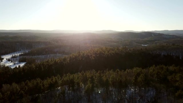 Aerial view panning sideways of Quebec forest at sunset