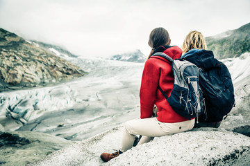Young Couple Hiking In The Swiss Alps, Taking A Break