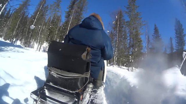 snowmobile rides on a snow-covered forest in Russia