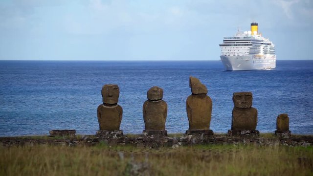 Easter Island statues with ship on water.