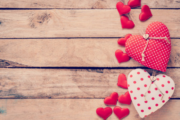 Heart fabric frame on wooden table background.