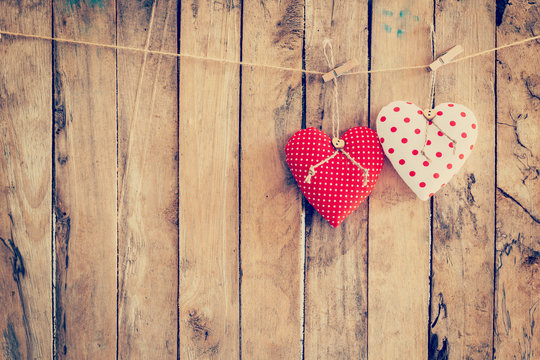 Two heart fabric hanging on clothesline and wood background with