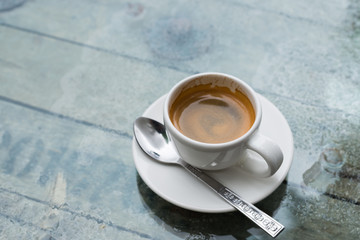 Espresso in white mug on glass table