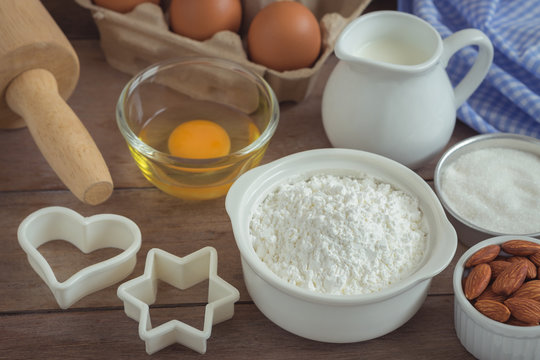 Baking ingredients flour, egg, milk, almonds, sugar on table
