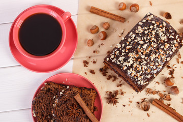 Dark cake with chocolate, cocoa and plum jam, cup of coffee, delicious dessert
