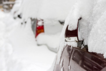 Car covered with snow in the parking after a snow storm