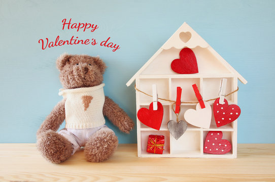 Wooden house with many hearts and cute teddy bear