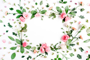 Round frame made of pink and beige roses, green leaves, branches on white background. Flat lay, top view. Valentine's background