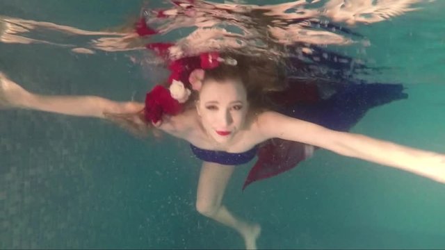 Young girl under water with flowers on her head