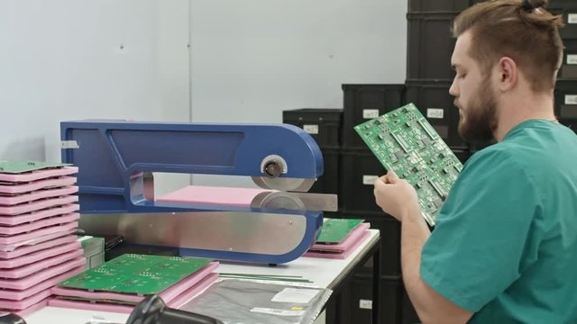 Technician using PCB cutting tool to separate material into few parts 