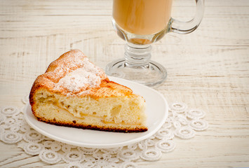 Apple pie and cappuccino on a light wooden background, close-up