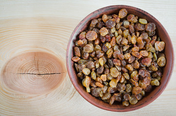 Dried Organic Raisin in Bowl on Wooden BackgroundClose-up.