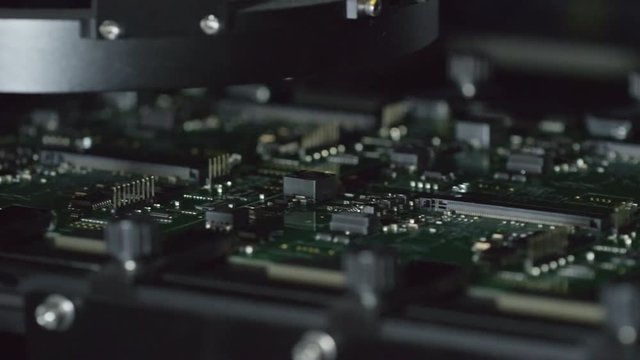 Closeup of machine scanning printed circuit board during process of manufacturing