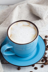 a cup of cappuccino on a wooden background close up