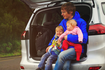 father with two little kids travel by car in nature